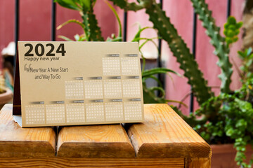 happy new year 2024 calendar on wooden board near garden