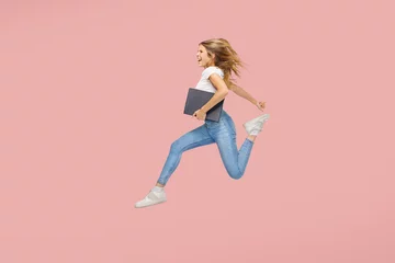 Fotobehang Full body side view young woman jump high work hold a business folder isolated on plain pink background - successful education concept. © Igor Link