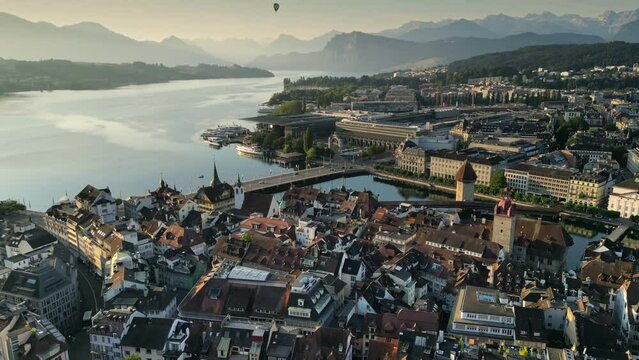 Chapel Bridge and old town of Lucerne. Flight at sunrise over city of Luzern, Swiss Alps and Lucerne lake on background