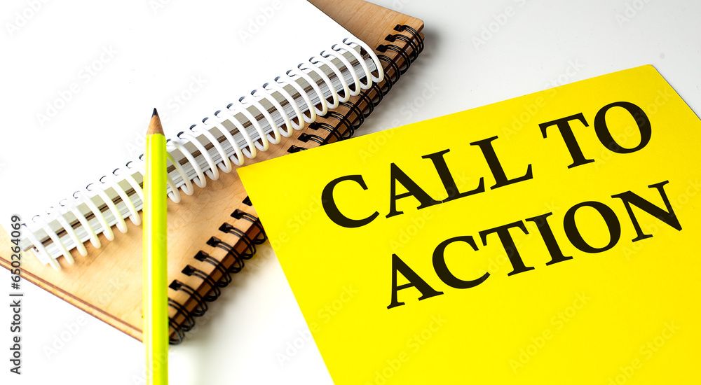 Poster call to action text written on a yellow paper with notebook