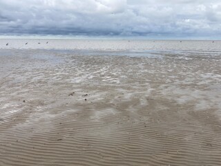 Die Nordsee bei Ebbe mit Markierungsbojen bei Wolken am Himmel