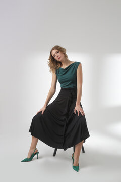Serie of studio photos of young female model wearing simple beautiful outfit, cotton black maxi skirt and green sleeveless top