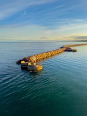 Small lighthouse at the end of a harbor pier