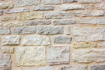 Stone wall. The wall is rocky, ancient, made of blocks, bricks. Ancient wall, surface.