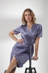 Fashion portrait of beautiful female model wearing elegant lavender color silk dress, studio shot on white background Female beauty, fashion and glamour concept.