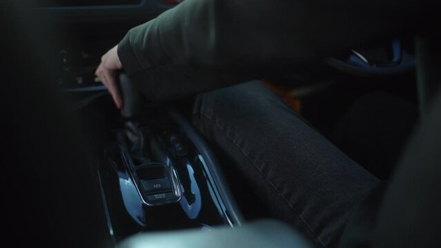 
Business woman in suit hand control the stick shift transmission in luxury car. Female hand changing gear driving car. slow motion shot. Success car dealer. Buy or rent car concept.
