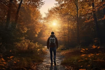 Poster A senior caucasian male is walking on a forest trail enjoying the surroundings with an autumn coat in a calm and tranquil forest during sunset and seen from the front - relaxing walking activity in sp © pangamedia
