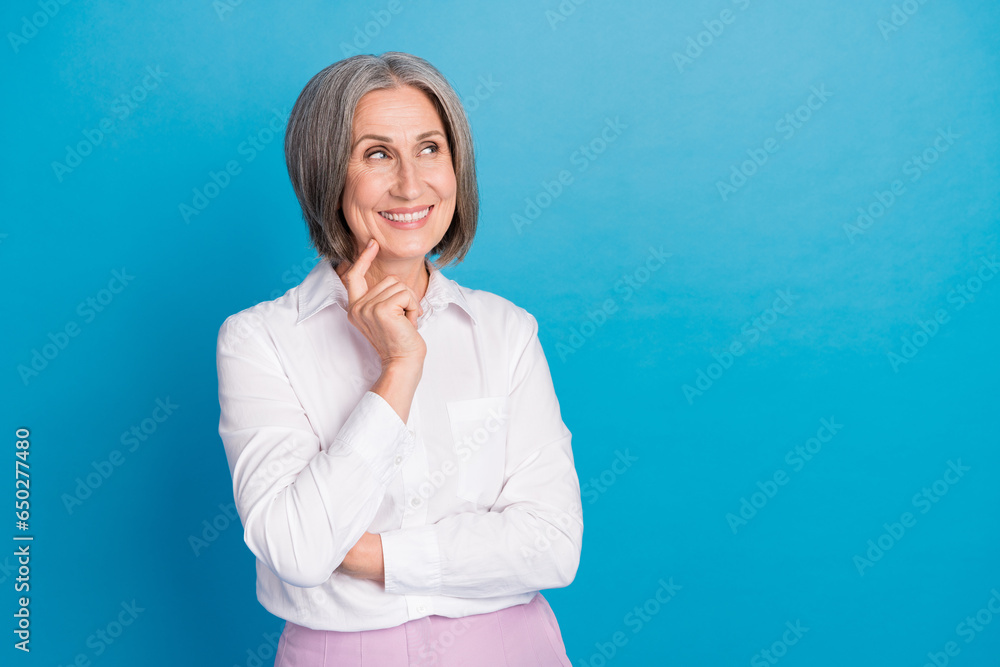 Sticker Photo of cheerful clever grandmother arm touch chin look interested empty space isolated on blue color background