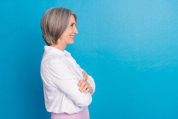 Profile photo of elegant cheerful aged person folded arms look empty space isolated on blue color background