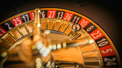 Glücksspiel Roulette mit Rouletterad im Casino an Roulettetisch mit Kugel auf einer roten Zahl