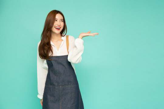 Restaurant Owner Small Business Asian Woman With Apron Presenting Or Showing Open Hand Palm With Copy Space For Product Isolated Over Green Background