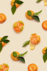 Orange yellow juicy tangerines with green leaves, whole and peeled on neutral beige background, geometric pattern. Citrus fruits mandarins, healthy fruits food concept, creative photo, top view