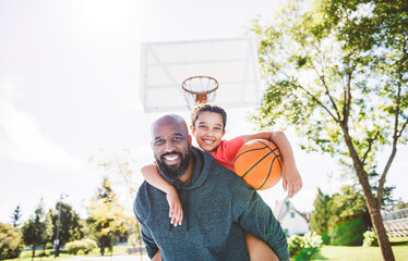 father and daughter playing basketball in the park