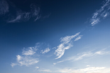 Deep blue sky with small white clouds. Natural background