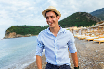 Handsome man walking alone on the beach