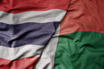 big waving national colorful flag of thailand and national flag of madagascar .