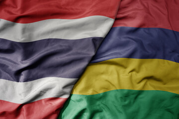 big waving national colorful flag of thailand and national flag of mauritius .
