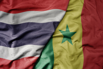 big waving national colorful flag of thailand and national flag of senegal .