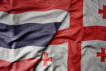big waving national colorful flag of thailand and national flag of georgia .