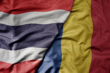 big waving national colorful flag of thailand and national flag of romania .