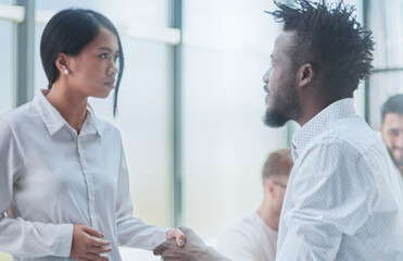 Obraz premium Business Handshake - business people shaking hands. Handshake between business man and woman indoors.