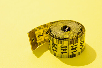 colorful measuring tapes high angle view on bright yellow background