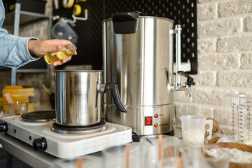 Woman pouring scent for candles, manufacturing process