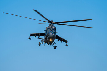 Soviet-made black Mi-24 military helicopter flying in the sky