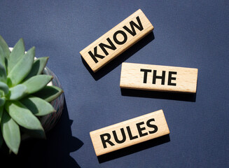 Know the rules symbol. Wooden blocks with words Know the rules. Beautiful deep blue background with...