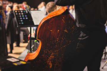 Concert view of violoncello player with vocalist and musical orchestra band, during jazz concert,...