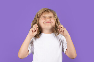 Portrait of cute smiling child crossed fingers, , isolated studio background. Child closed eyes,...