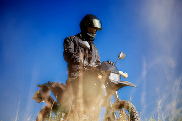 motorcyclist on an off-road enduro motard motorcycle against the sky, motorcyclist in equipment