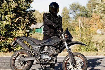 motorcyclist on an off-road enduro motorcycle in the countryside, motorcycle equipment and shoes.