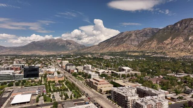 Aerial Provo Utah neighborhood to business buildings pull. Aerial Provo Utah downtown business shopping building. Urban city office, buildings business headquarters along street traffic. Neighborhood.