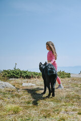 Kid playing with a dog in the mountain 