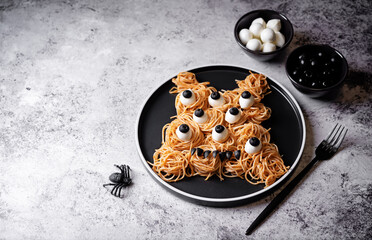 Tomato sauce Halloween pasta with mozzarella cheese and black olives in the form of monster