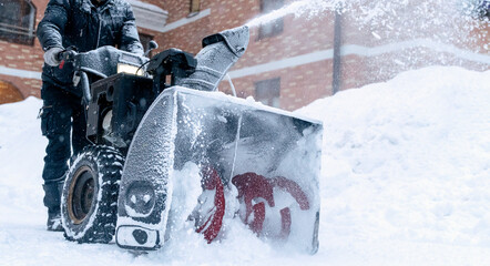 the janitor removes snow with a snow plow