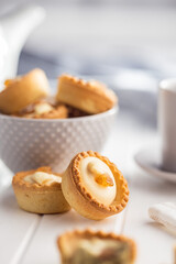 Sweet tarlets. Tasty mini tarts. Mini pie with cream on kitchen table.