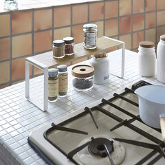 Different spices in jars on the rack in kitchen interior, close up