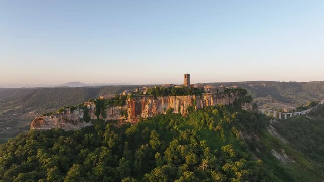Aerial summer sunrise view of famous Civita di Bagnoregio village, located on top of a volcanic tuff hill overlooking the Tiber river valley, province of Viterbo, Lazio, Italy