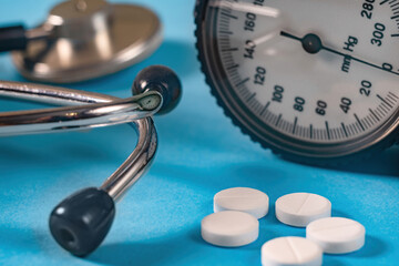Blood pressure monitor and pressure relief pills on a blue background