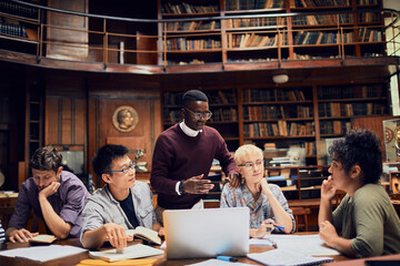 Young and diverse group of college students studying in a college library together