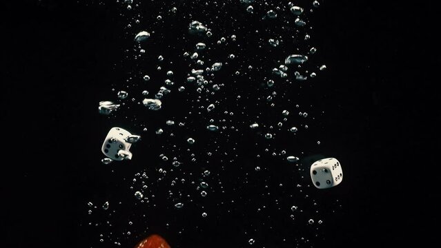 Group of colorful dice splashing on the water with black background