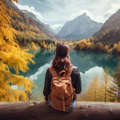 Foto op Aluminium Solo female traveller on a gap year sits by a lake beneath an awe inspiring mountain range © PieBase