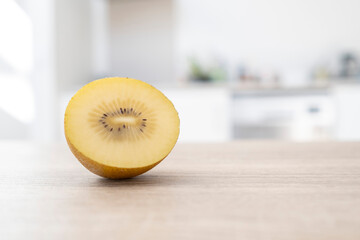 Slice of yellow kiwi fruit isolated on table