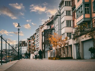 people are walking on the sidewalk in front of buildings in a city