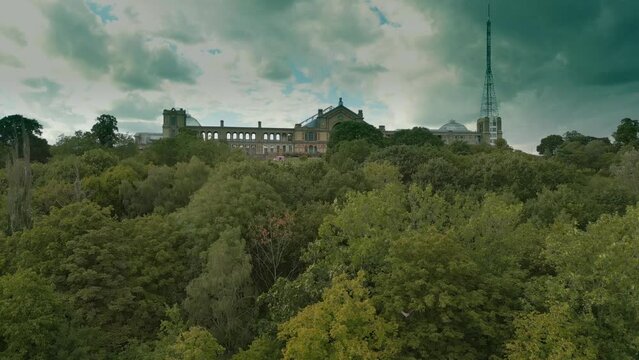 Aerial video of trees in the park and Alexandra Palace Sports venue in London, England