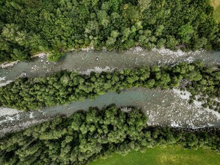 View of a winding river snaking through a lush forest in Switzerland