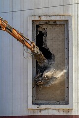 Orange construction excavator machine in operation on a demolition job