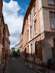 Narrow street lined with red brick buildings in Toulouse
